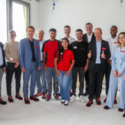 HWK26-3 Die drei kolumbianischen Fachkräfte sind auf der Baustelle. Das Foto ist ein Gruppenbild mit Vertreter:innen des FIT for German Climate Businesses-Projekts, der Handwerkskammer Niederbayern-Oberpfalz, des Betriebs DEHN Instatec und natürlich mit den Fachkräften in der Mitte der Gruppe.